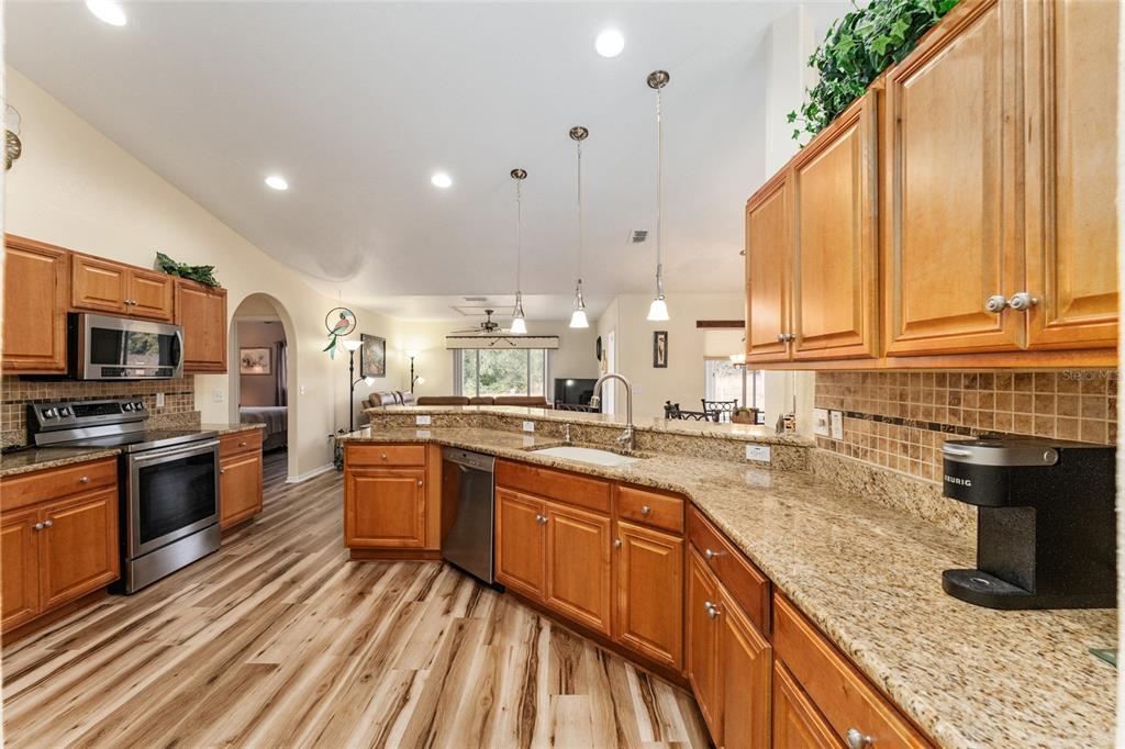 9910 Southeast 138th Loop Summerfield, FL 34491 - Photo 14 of 69 a kitchen with stainless steel appliances granite countertop sink stove and granite counter top