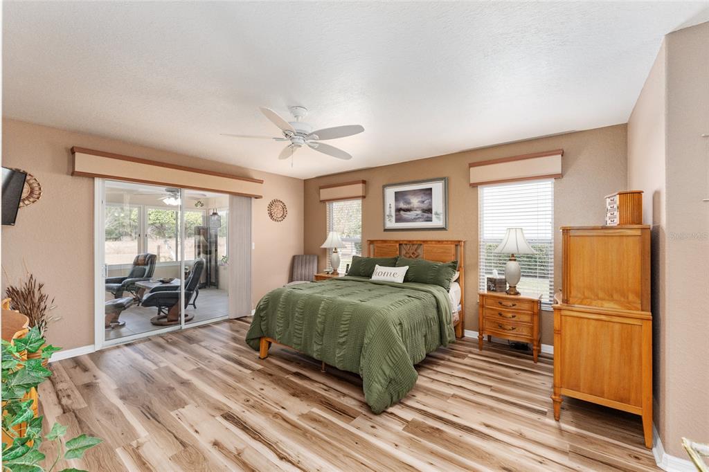 9910 Southeast 138th Loop Summerfield, FL 34491 - Photo 22 of 69 a spacious bedroom with a bed and wooden floor
