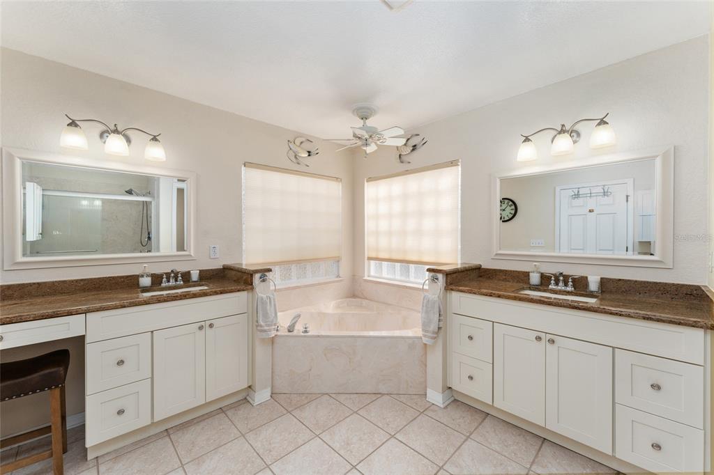 9910 Southeast 138th Loop Summerfield, FL 34491 - Photo 27 of 69 a bathroom with a granite countertop double vanity sink a mirror and a bathtub