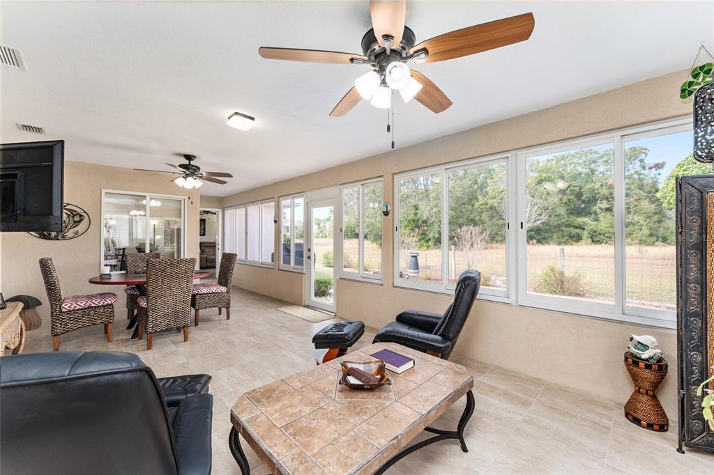 9910 Southeast 138th Loop Summerfield, FL 34491 - Photo 38 of 69 a living room with furniture a flat screen tv and a large window