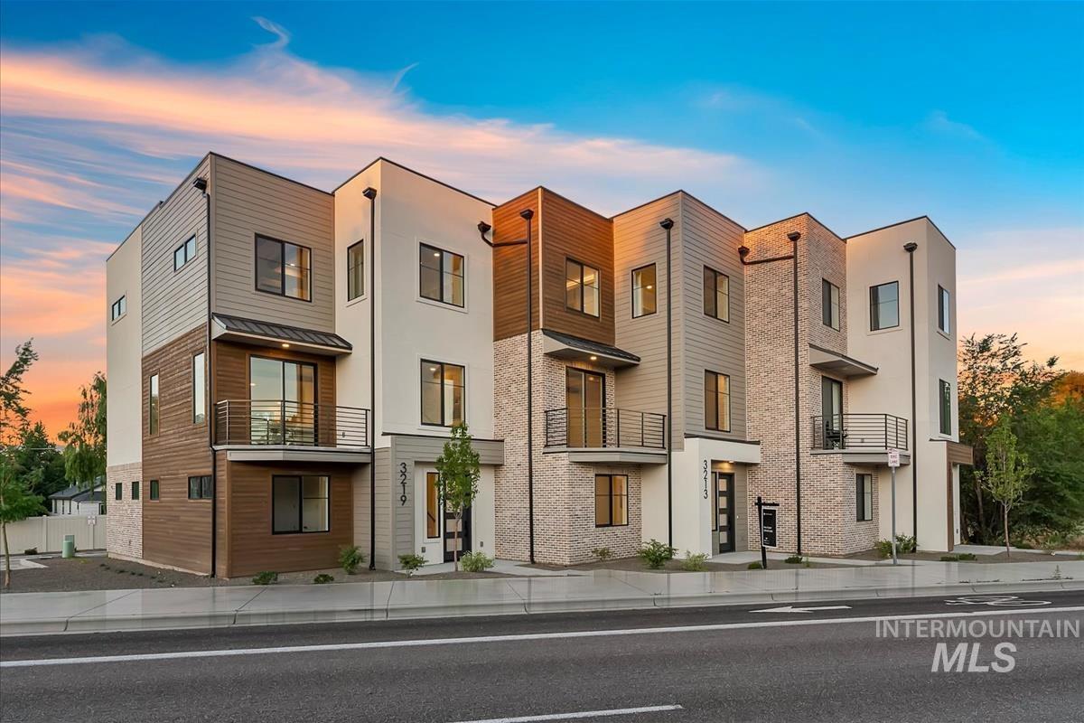 3219 West Moore Street Boise, ID 83702 - Photo 1 of 36 Modern townhome exterior featuring multi-textured facade with stucco, horizontal wood-finish siding, and brick accents