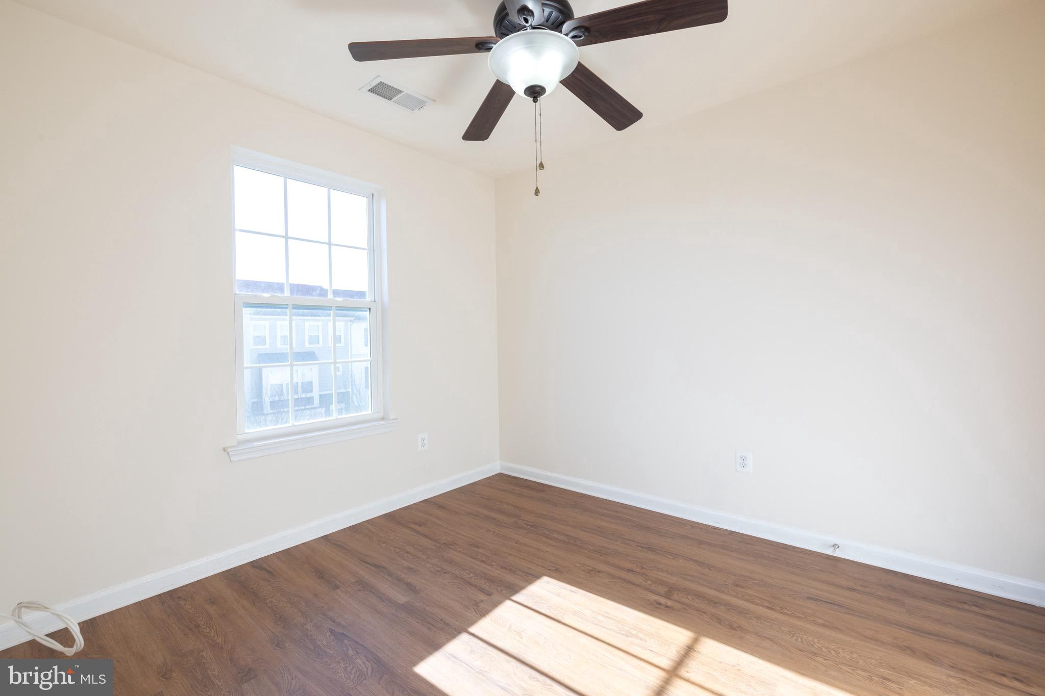 202 Fiesta Drive Stephenson, VA 22656 - Photo 14 of 33 an empty room with wooden floor chandelier fan and windows