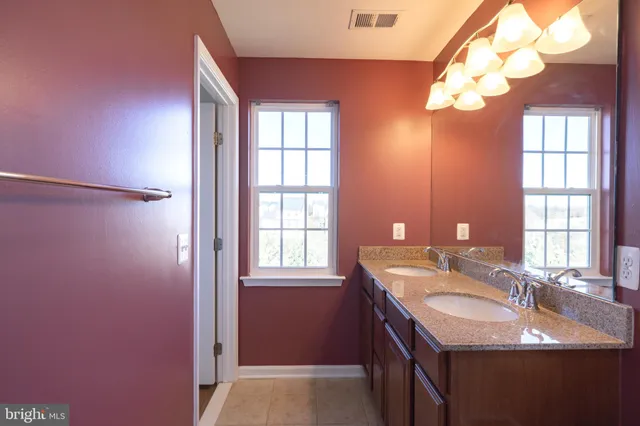 an empty room with wooden floor chandelier fan and windows