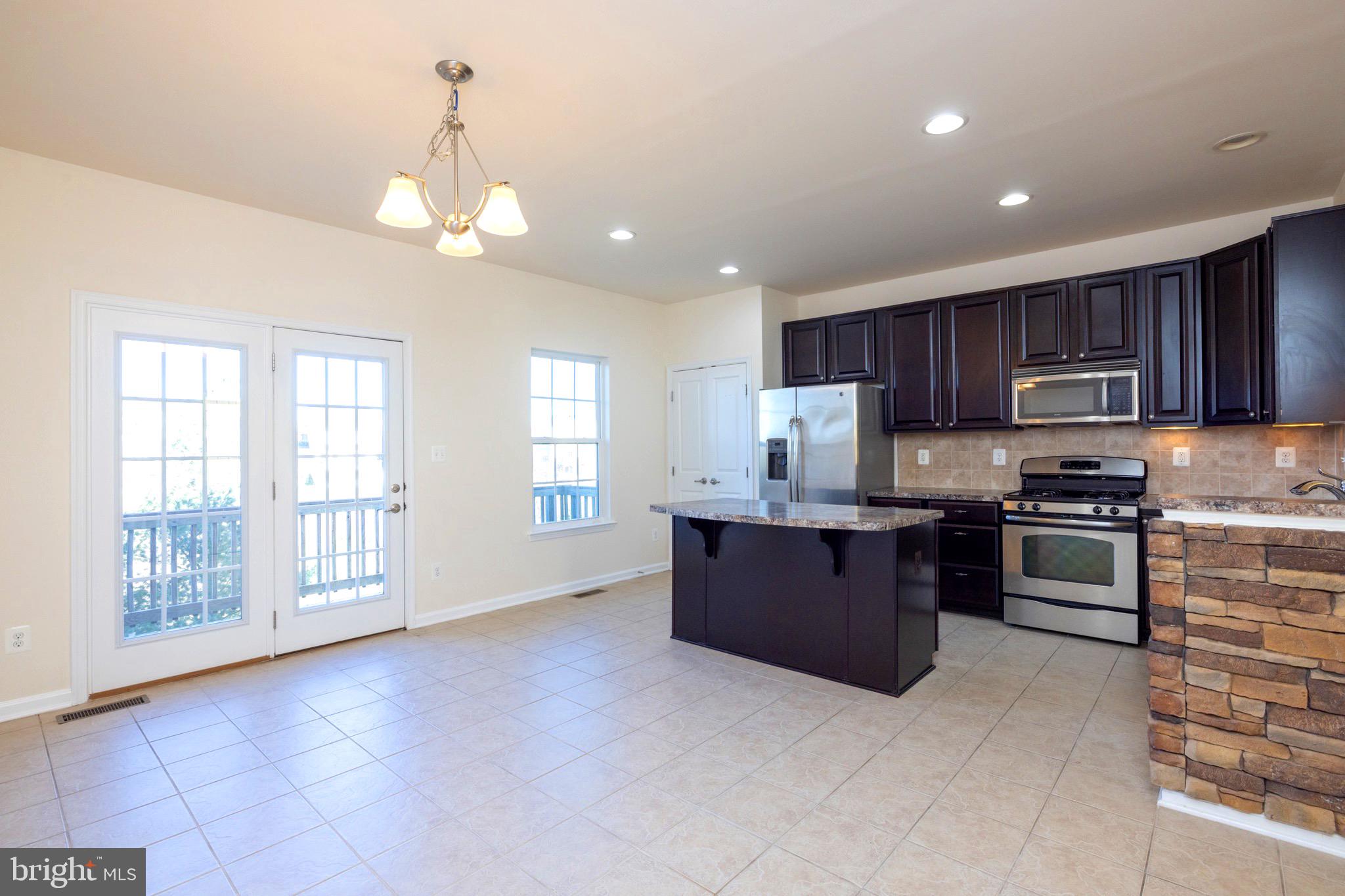 202 Fiesta Drive Stephenson, VA 22656 - Photo 7 of 33 a large kitchen with kitchen island granite countertop a stove top oven a sink a counter space and cabinets