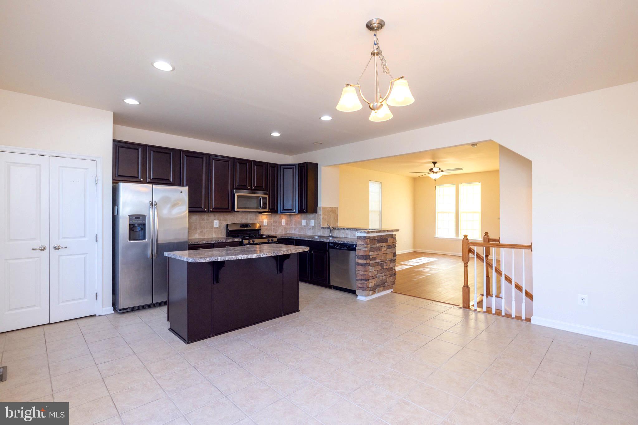 202 Fiesta Drive Stephenson, VA 22656 - Photo 8 of 33 a kitchen with stainless steel appliances granite countertop a refrigerator a sink dishwasher a oven and a dining table with the view of kitchen