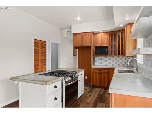 a kitchen with stainless steel appliances granite countertop a sink stove and cabinets