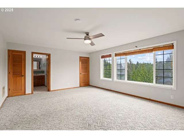 a view of empty room with a ceiling fan and window