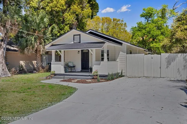 a view of a house with a yard and large tree