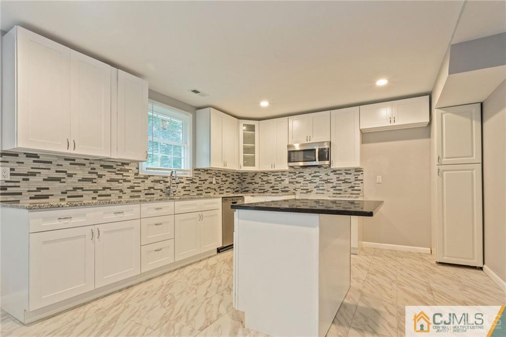 65 Tunison Road New Brunswick, NJ 08901 - Photo 7 of 22 a kitchen with stainless steel appliances granite countertop a sink and cabinets