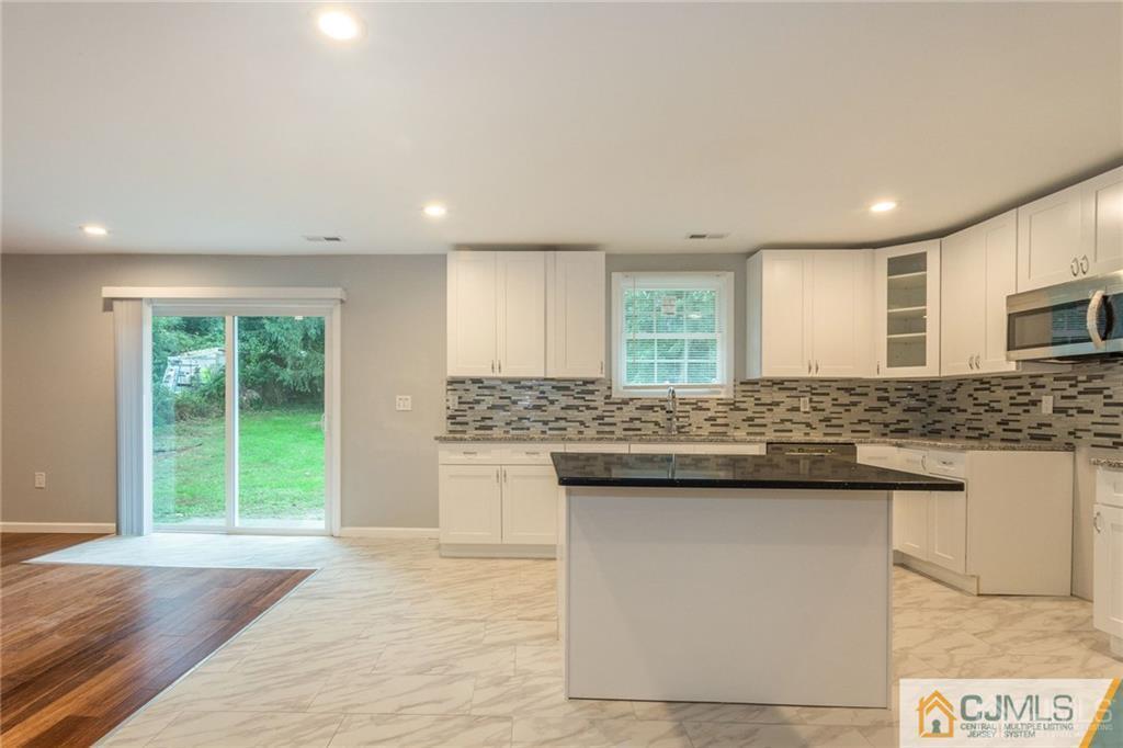65 Tunison Road New Brunswick, NJ 08901 - Photo 8 of 22 a kitchen with kitchen island granite countertop a sink and a stove top oven