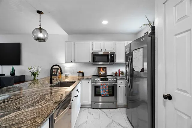 a kitchen with stainless steel appliances granite countertop a stove sink microwave and refrigerator