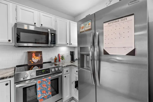 a kitchen with stainless steel appliances granite countertop a stove a microwave and a refrigerator
