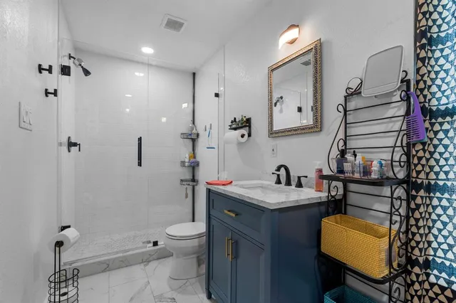 a bathroom with a granite countertop sink toilet and shower