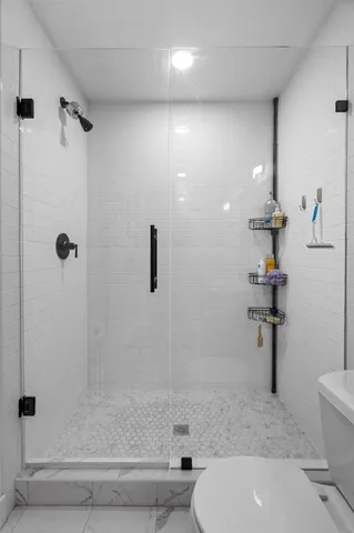 a bathroom with a sink a toilet and shower