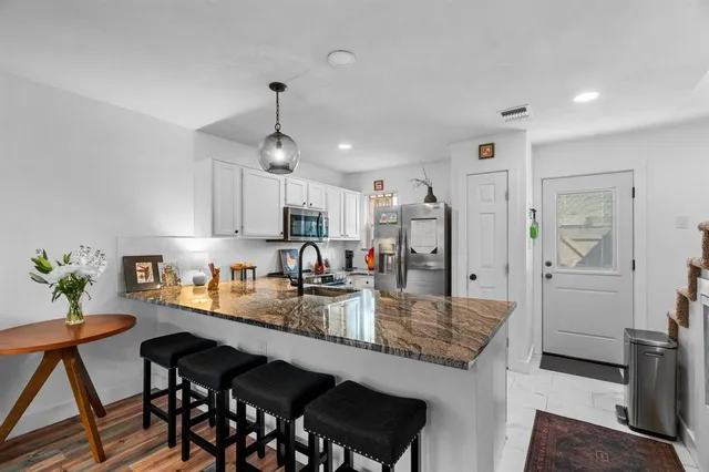 a kitchen with granite countertop counter space dining table and stainless steel appliances