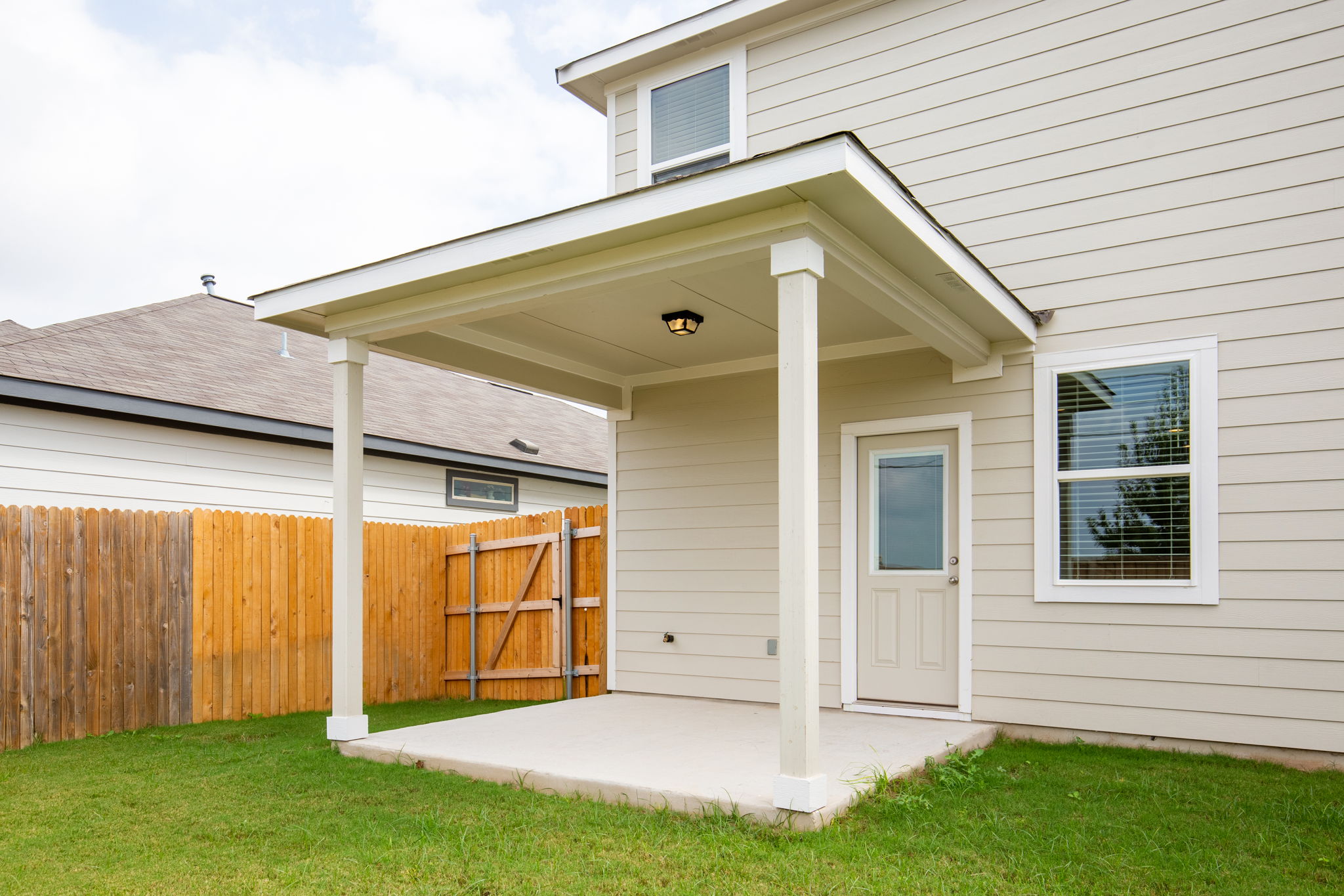 1624 Caballo Blanco Road Austin, TX 78725 - Photo 26 of 27 A covered concrete patio provides sheltered outdoor living space adjacent to the grassy yard.