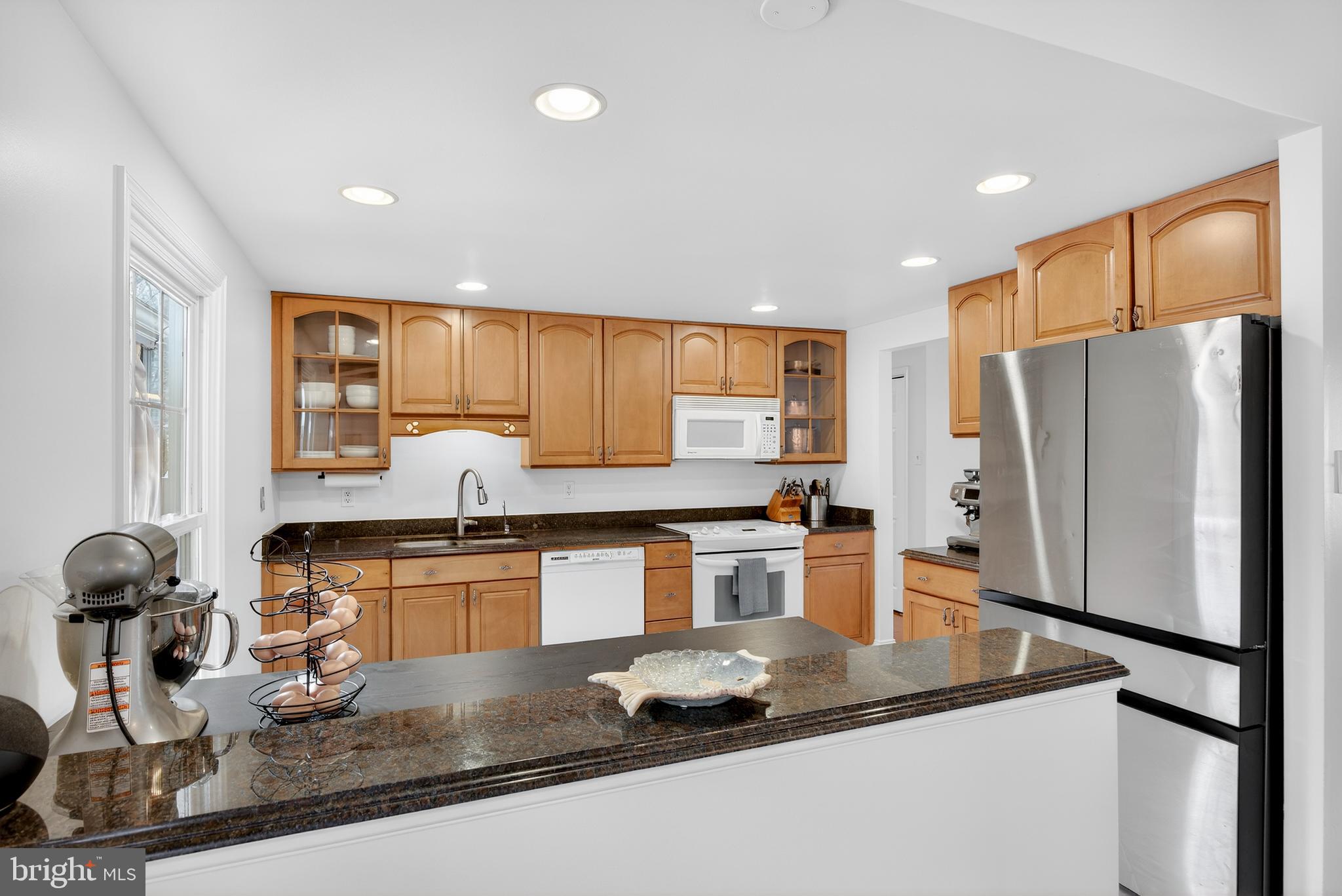 939 Shore Acres Road Arnold, MD 21012 - Photo 6 of 32 a kitchen with granite countertop a refrigerator a stove a sink a counter space and cabinets