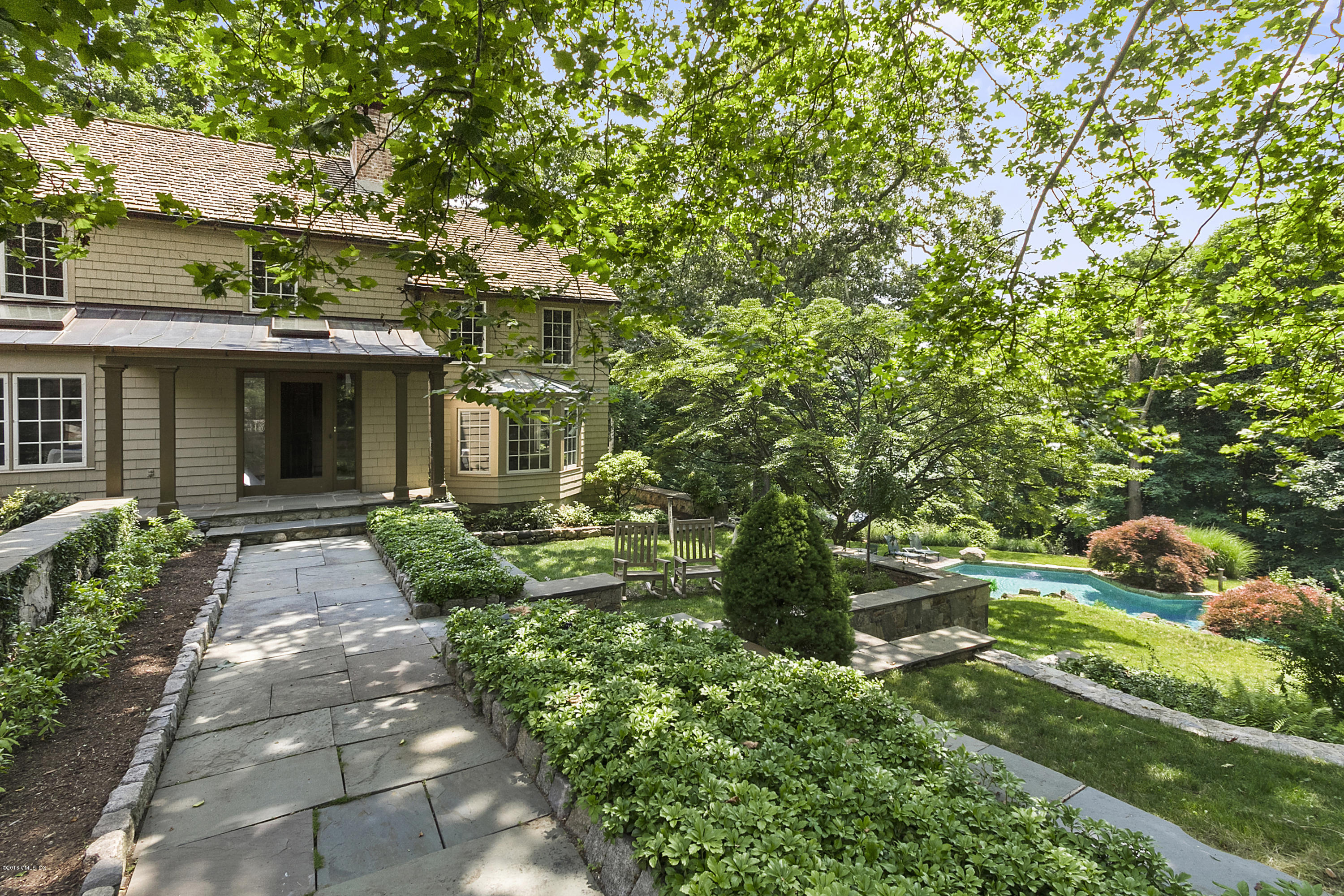 467 Laurel Road New Canaan, CT 06840 - Photo 27 of 29 a front view of a house with a yard and potted plants