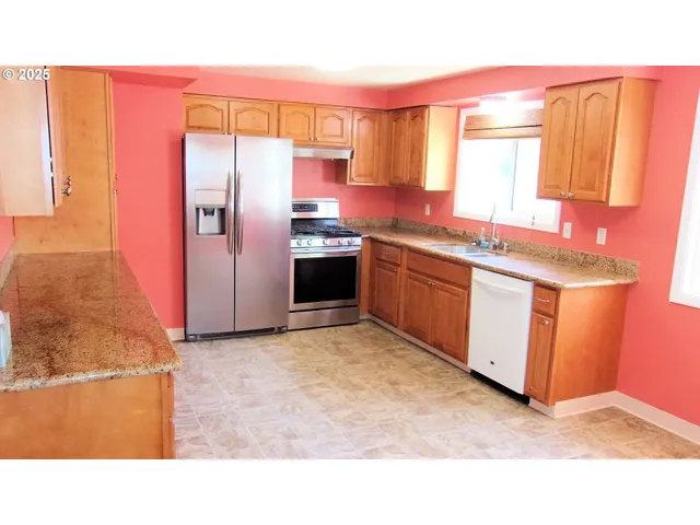 a kitchen with stainless steel appliances granite countertop a refrigerator a sink a stove and island