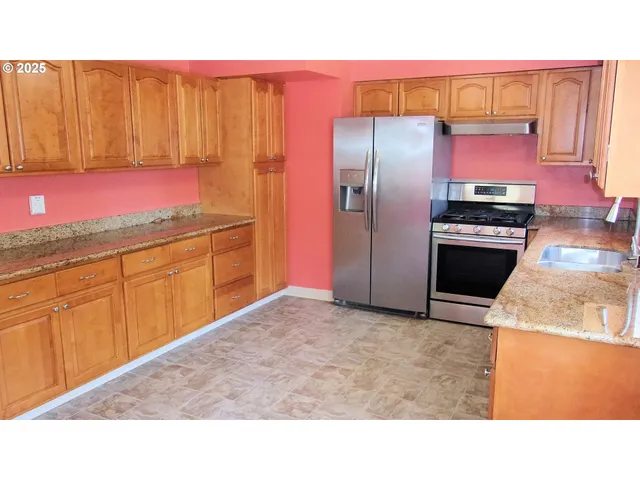 a kitchen with stainless steel appliances granite countertop a refrigerator a sink dishwasher with a dining table and chairs