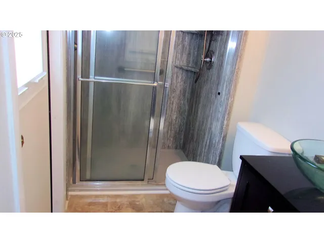 a bathroom with a toilet a sink and shower