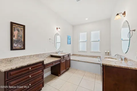 a spacious bathroom with a granite countertop bathtub sink and mirror