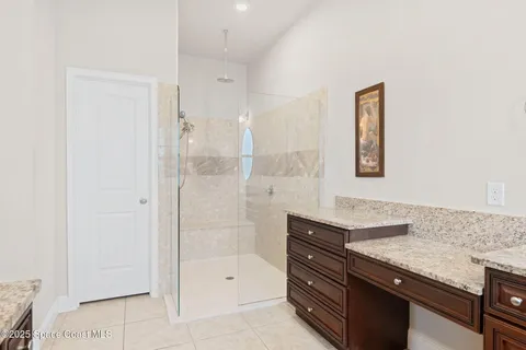 a bathroom with a granite countertop sink a mirror and a shower