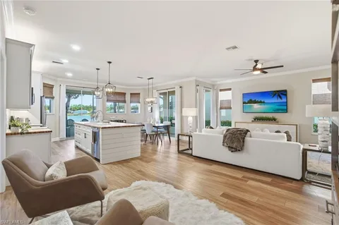 a living room with furniture kitchen view and a large window