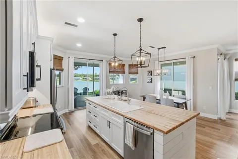 a view of a kitchen counter top space with stainless steel appliances granite countertop furniture and a chandelier