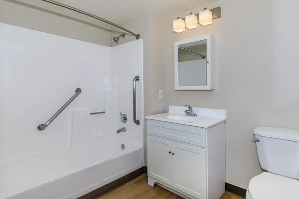 a bathroom with a sink a toilet and shower