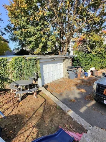 a view of a patio with table and chairs and a large tree