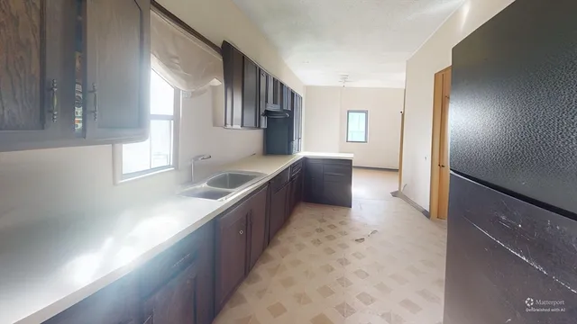 a kitchen with granite countertop a refrigerator and a sink