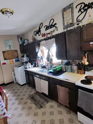 a kitchen with kitchen island granite countertop a sink stove and cabinets