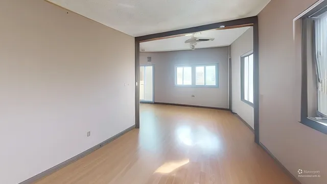 a view of a room with wooden floor and window