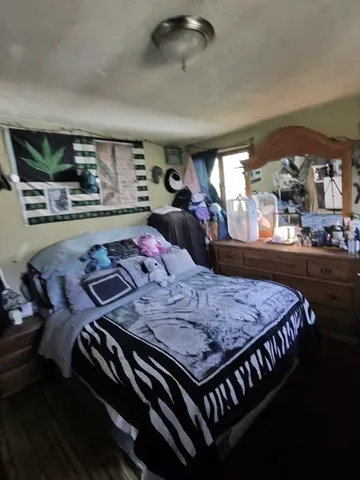 a bed room with a bed furniture and a flat tv screen