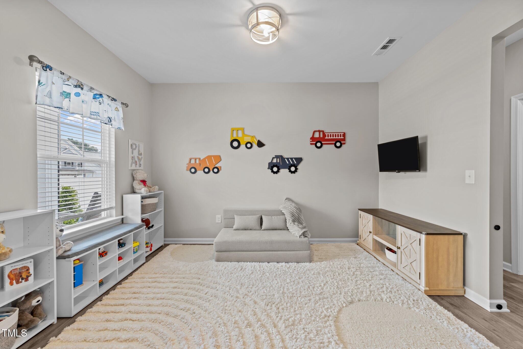 3613 Cross Timber Lane Raleigh, NC 27603 - Photo 6 of 33 a bedroom with a bed a window and a flat screen television