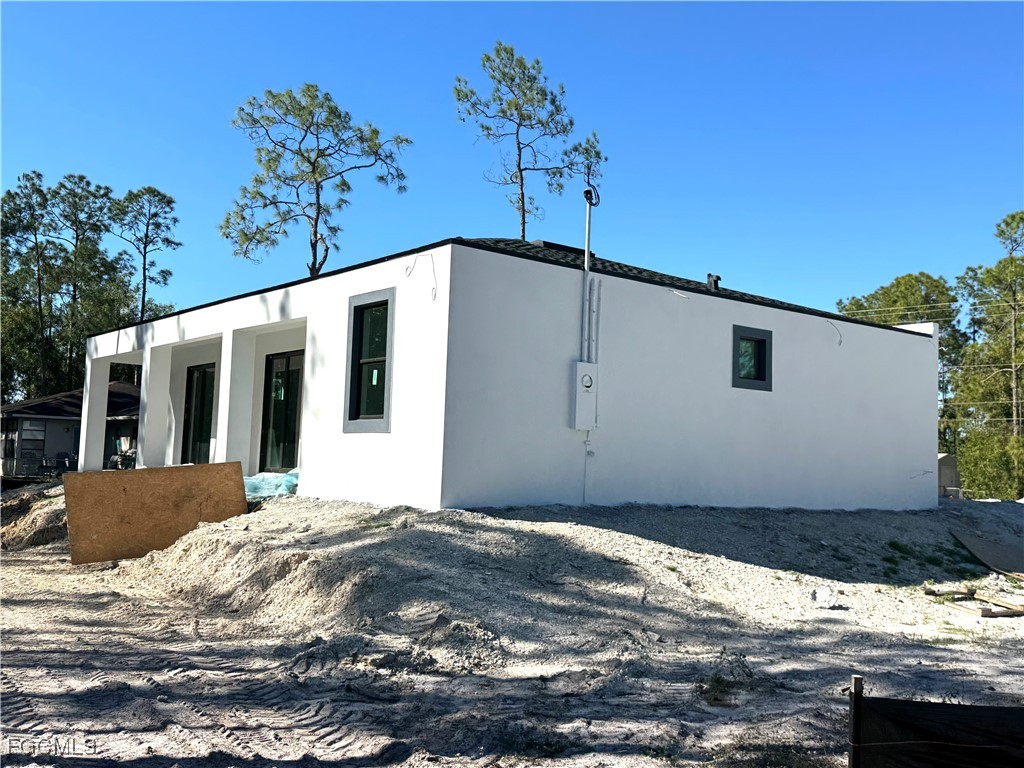3306 East 2nd Street Lehigh Acres, FL 33936 - Photo 6 of 7 a front view of a house with a yard