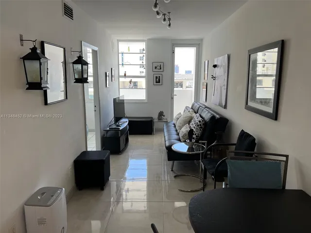 a bedroom with a bed and a flat tv screen on dresser