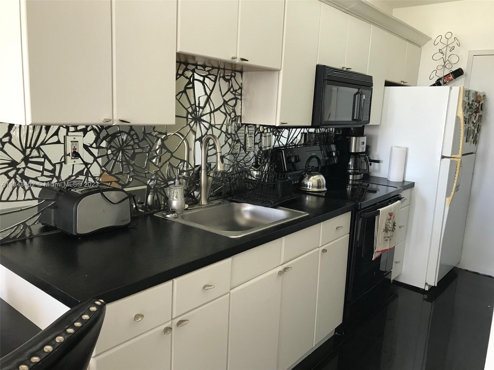 100 Lincoln Road, Unit 1007 Miami Beach, FL 33139 - Photo 12 of 80 a kitchen with a sink and refrigerator
