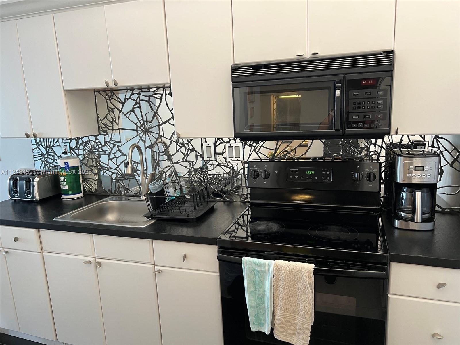 100 Lincoln Road, Unit 1007 Miami Beach, FL 33139 - Photo 13 of 80 a kitchen with a sink and cabinets