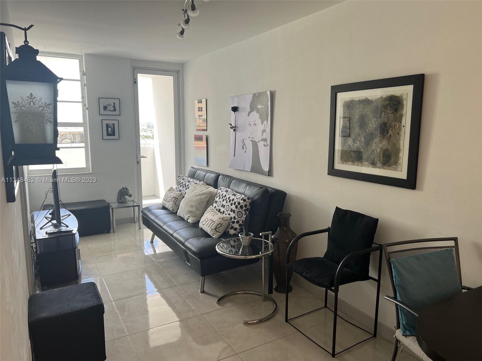 100 Lincoln Road, Unit 1007 Miami Beach, FL 33139 - Photo 8 of 80 a living room with furniture and a lamp