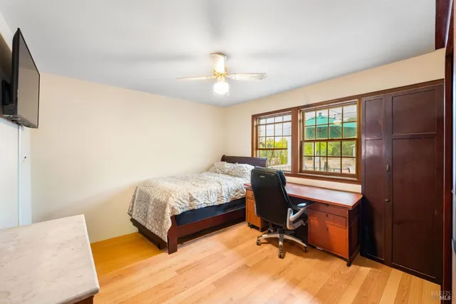 a bedroom with a bed tv and a window