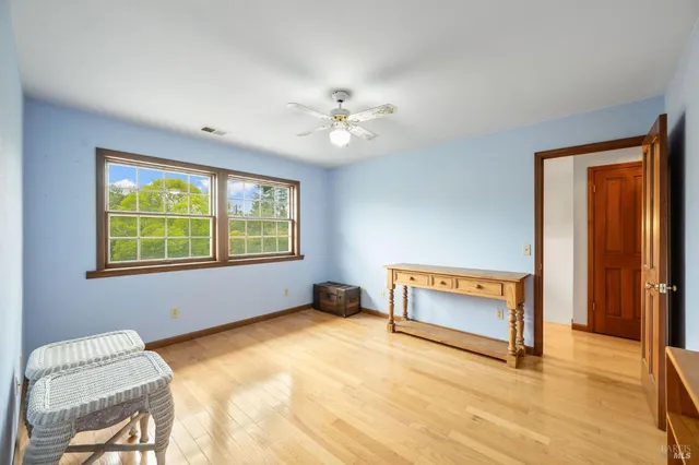a view of an empty room with a window and a kitchen