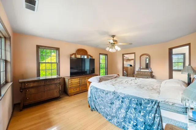 a spacious bedroom with a bed and a flat screen television