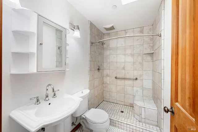 a bathroom with a sink a toilet and a mirror