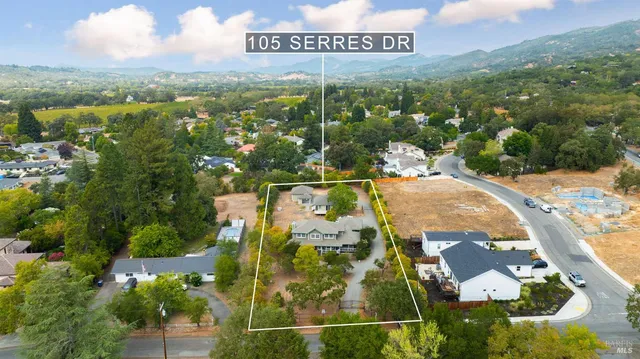 an aerial view of a house with a yard and lake view