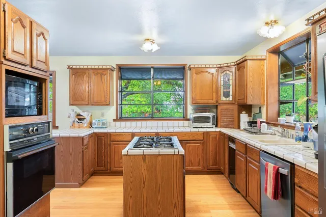 a kitchen with stainless steel appliances a stove sink and cabinets