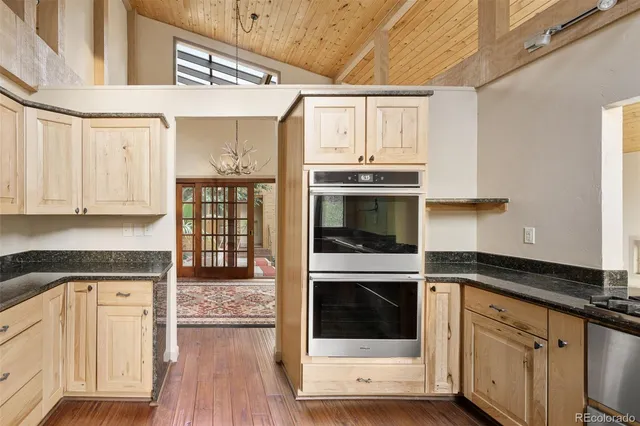 a kitchen with granite countertop stainless steel appliances a sink and cabinets