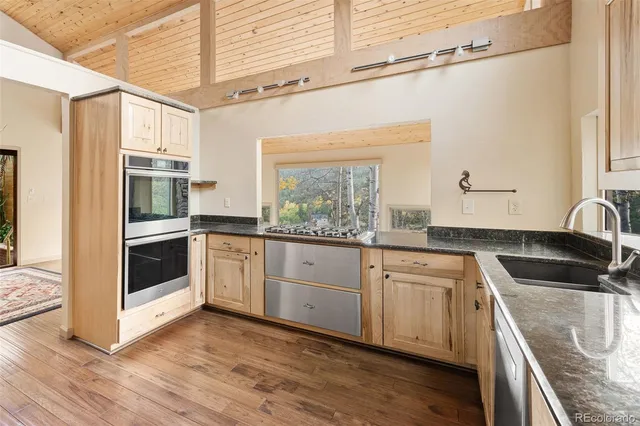 a kitchen with granite countertop white cabinets and stainless steel appliances