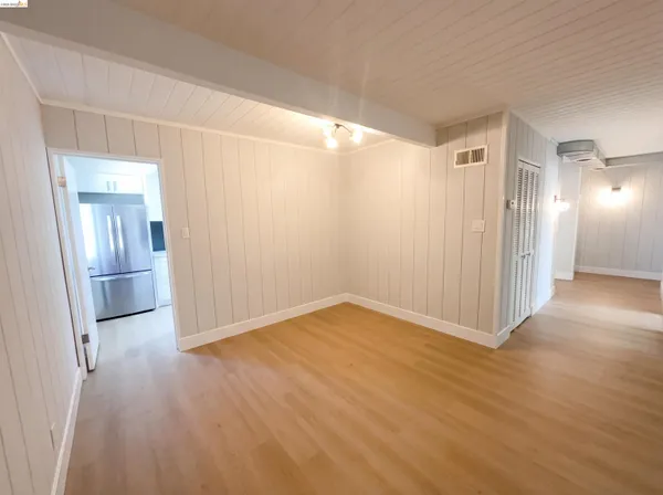 a view of empty room with wooden floor